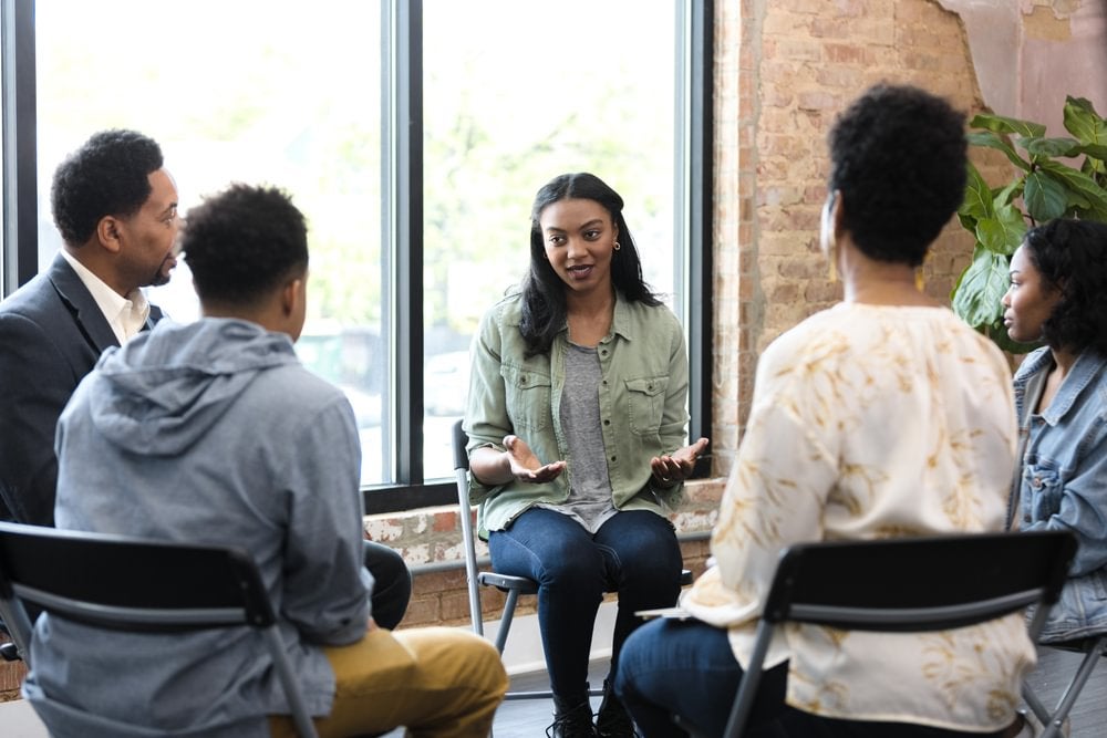 A mental health professional doing group counselling.