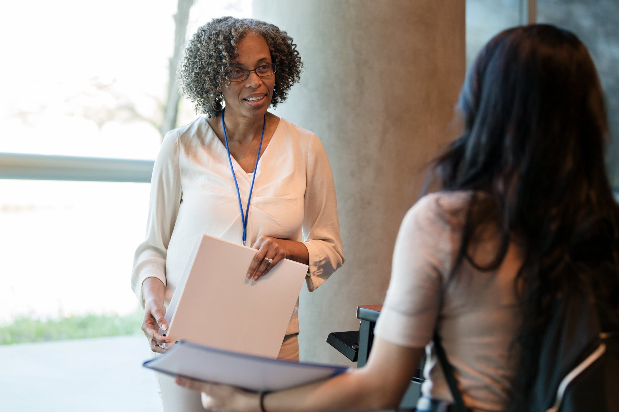 Adult female school principal takes time to listen to the young adult female student.