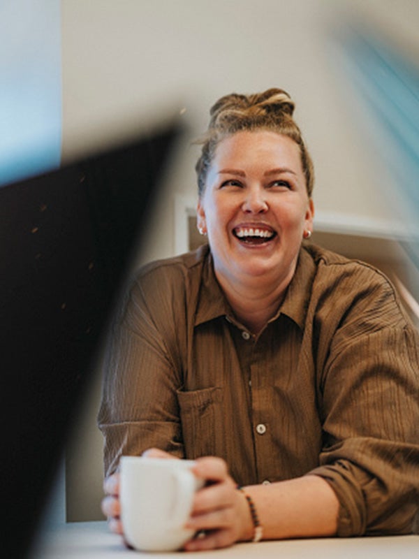 One UC online student reading a book and smiling