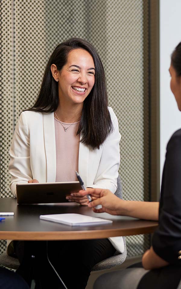 a UC online student in suit standing behind a lectern, looking out into the crowd, smiling