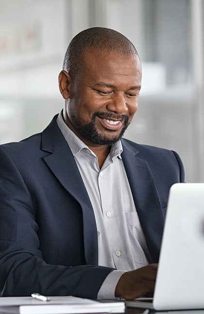 One UC online student reading a book and smiling