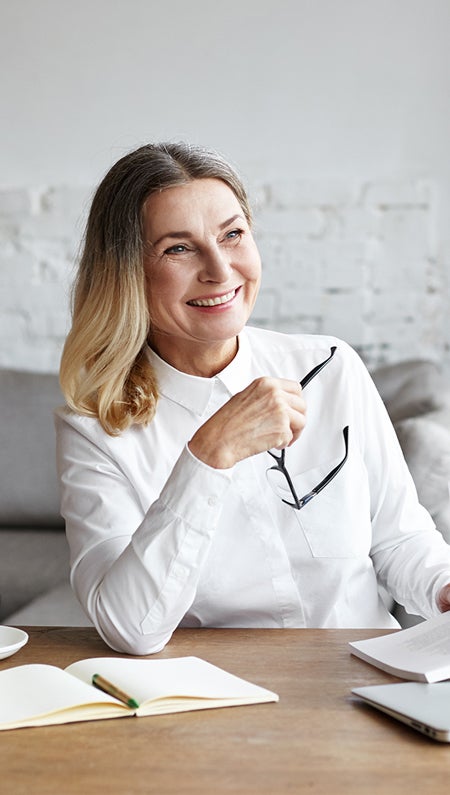 One UC online student reading a book and smiling