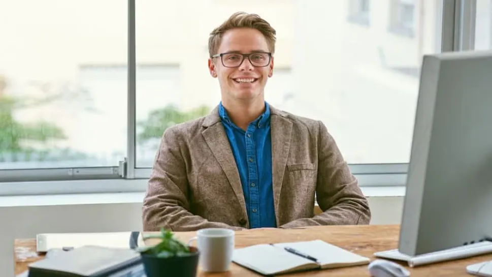 A confident professional man sits at a desk with a computer, representing the qualities of good public policy