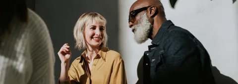 A man and woman engage in conversation, facing each other with attentive expressions.