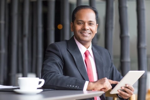 A business leader smiling while deciding between an MBA or JD.