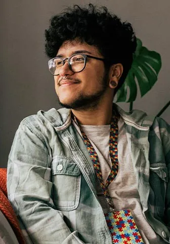 A man wearing glasses is sitting comfortably on a couch.