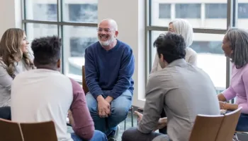 A supportive mental health social worker engages with clients in a professional setting in Australia.